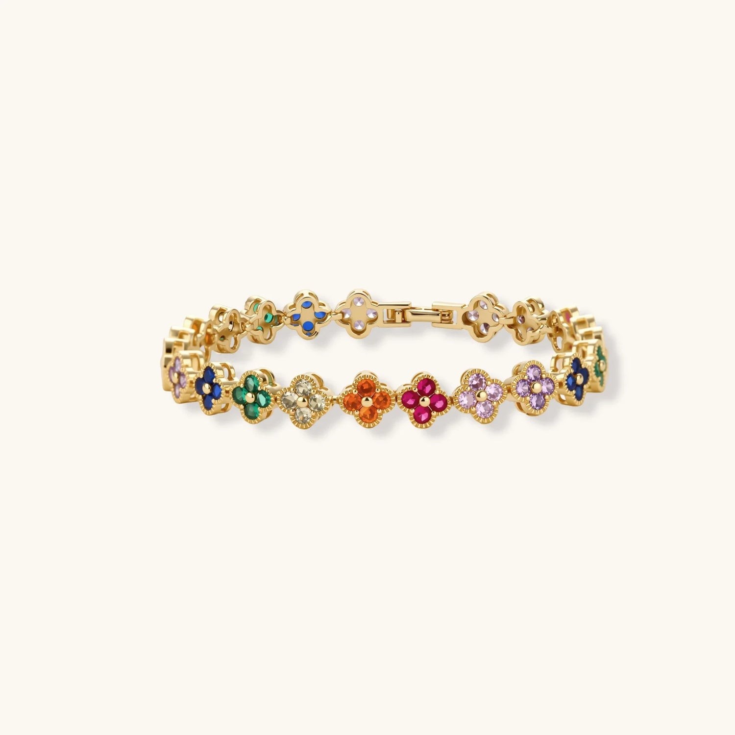 Colorful four-leaf clover jewelry set with rainbow cubic zirconia stones in gold-plated setting on white background