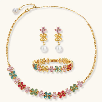 Gold-plated jewelry set with pink, turquoise and red flower-shaped cubic zirconia stones, featuring necklace, earrings and bracelet.