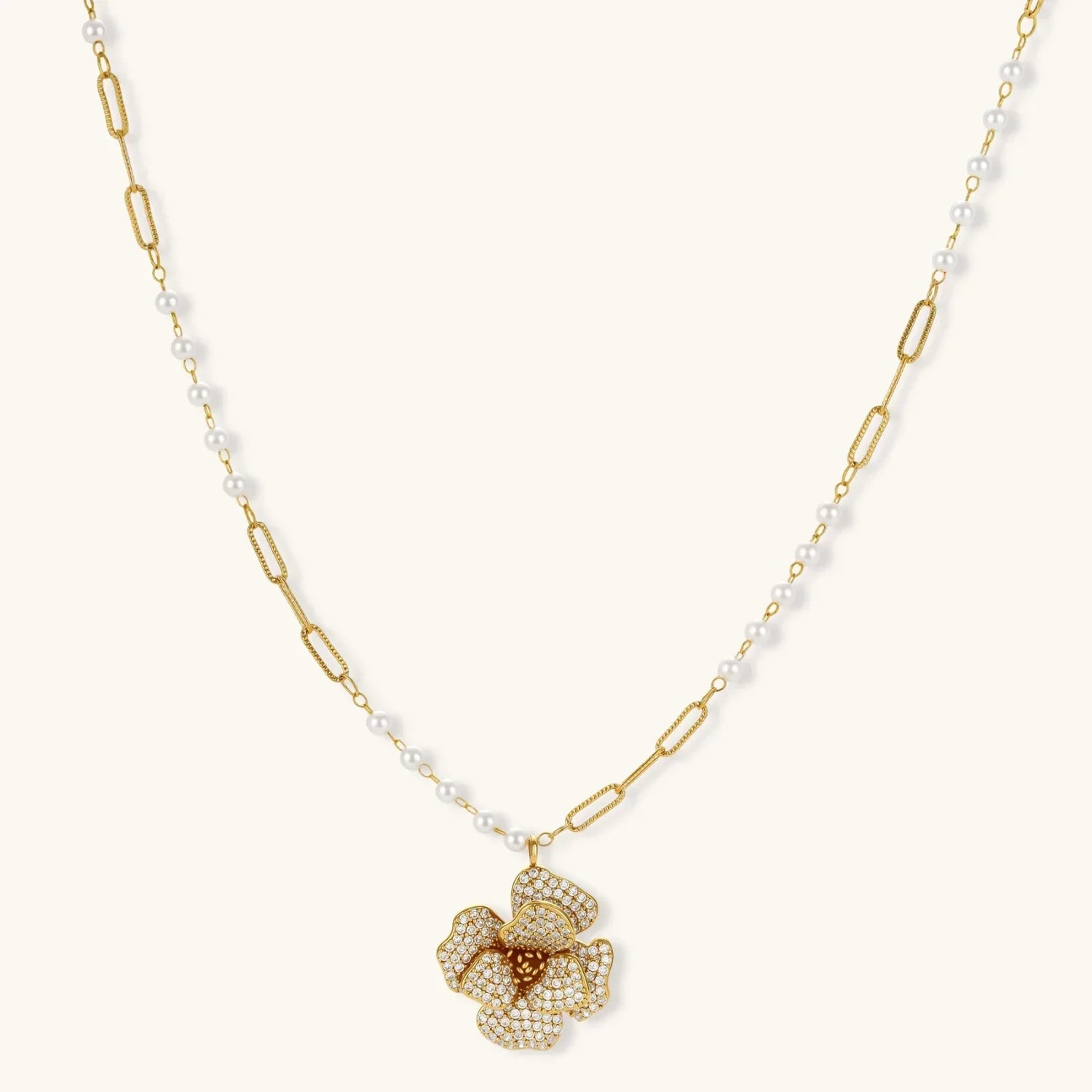 14K gold-plated floral jewelry set with blue cubic zirconia centers and pearl chain details on white background.