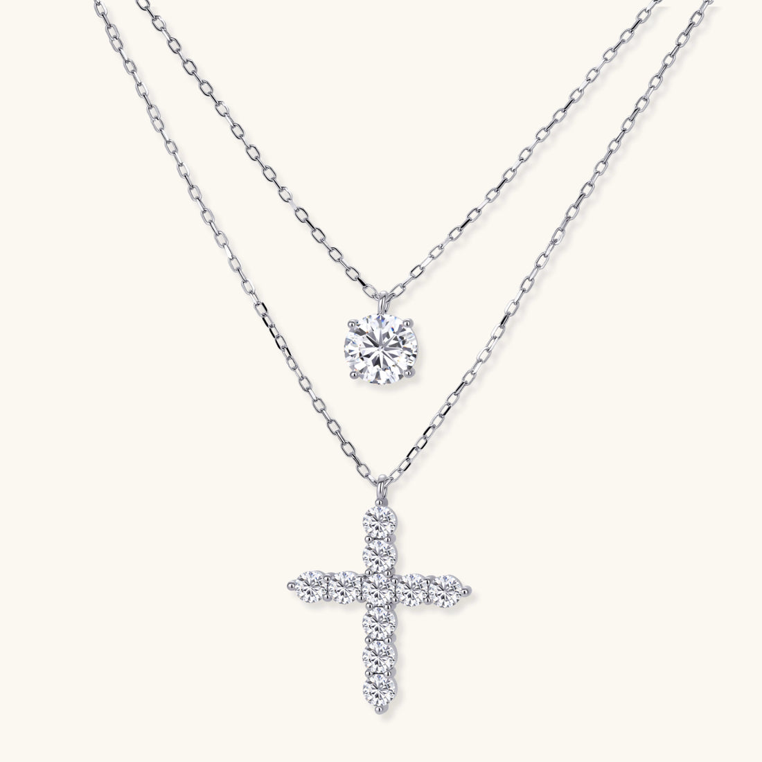 Two delicate sterling silver necklaces with moissanite stones - one solitaire pendant and one cross pendant on white background.