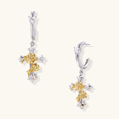 Two-tone huggie hoops with gold rose crosses and star zirconia accents on cream background